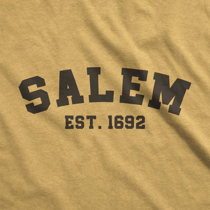 A mustard yellow Bella Canvas swatch that says Salem Est. 1692.