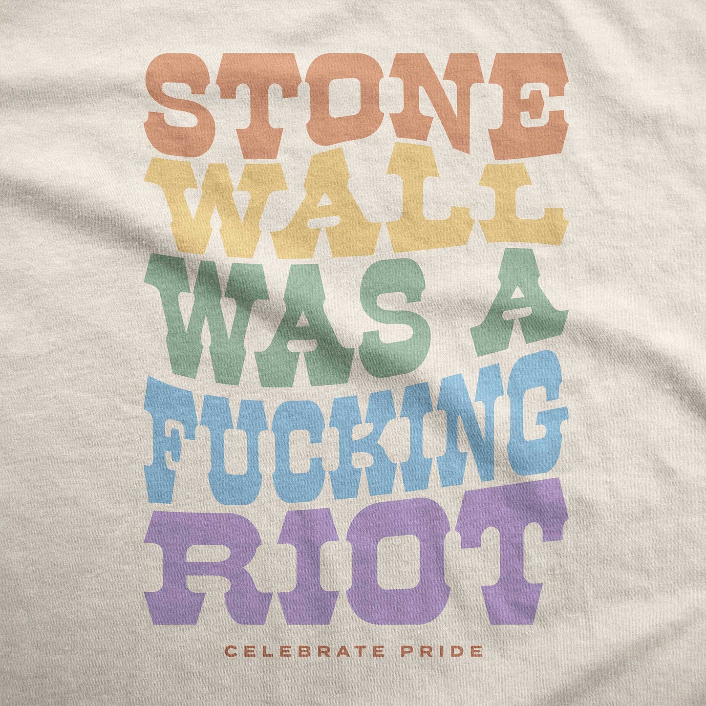 A soft cream Bella Canvas swatch with that says Stonewall was a fucking riot celebrate pride