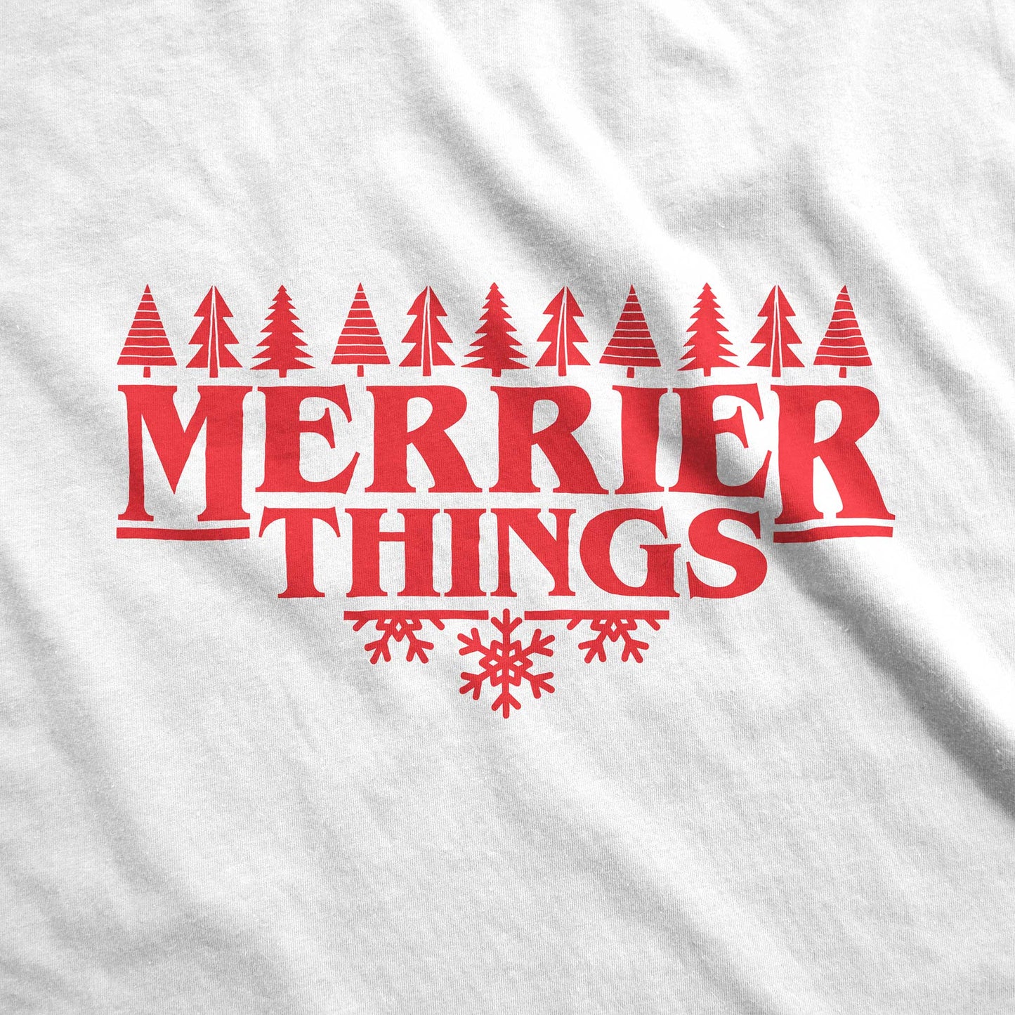 A white Gildan fabric swatch featuring the words merrier things surrounded by trees and snowflakes.