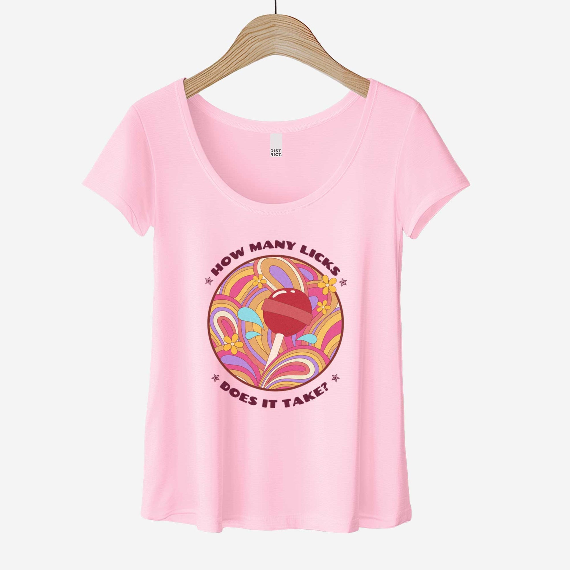 A hanging lilac District 7501 scoop neck t-shirt featuring a psychedelic circle with a candy lollipop in the center and the words how many licks does it take.