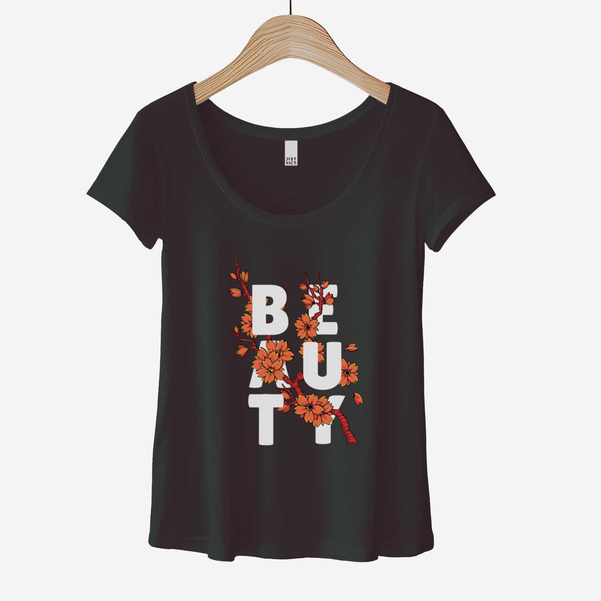 A hanging black District 7501 scoop neck t-shirt featuring orange cherry blossoms and the words beauty intertwined in the branches.