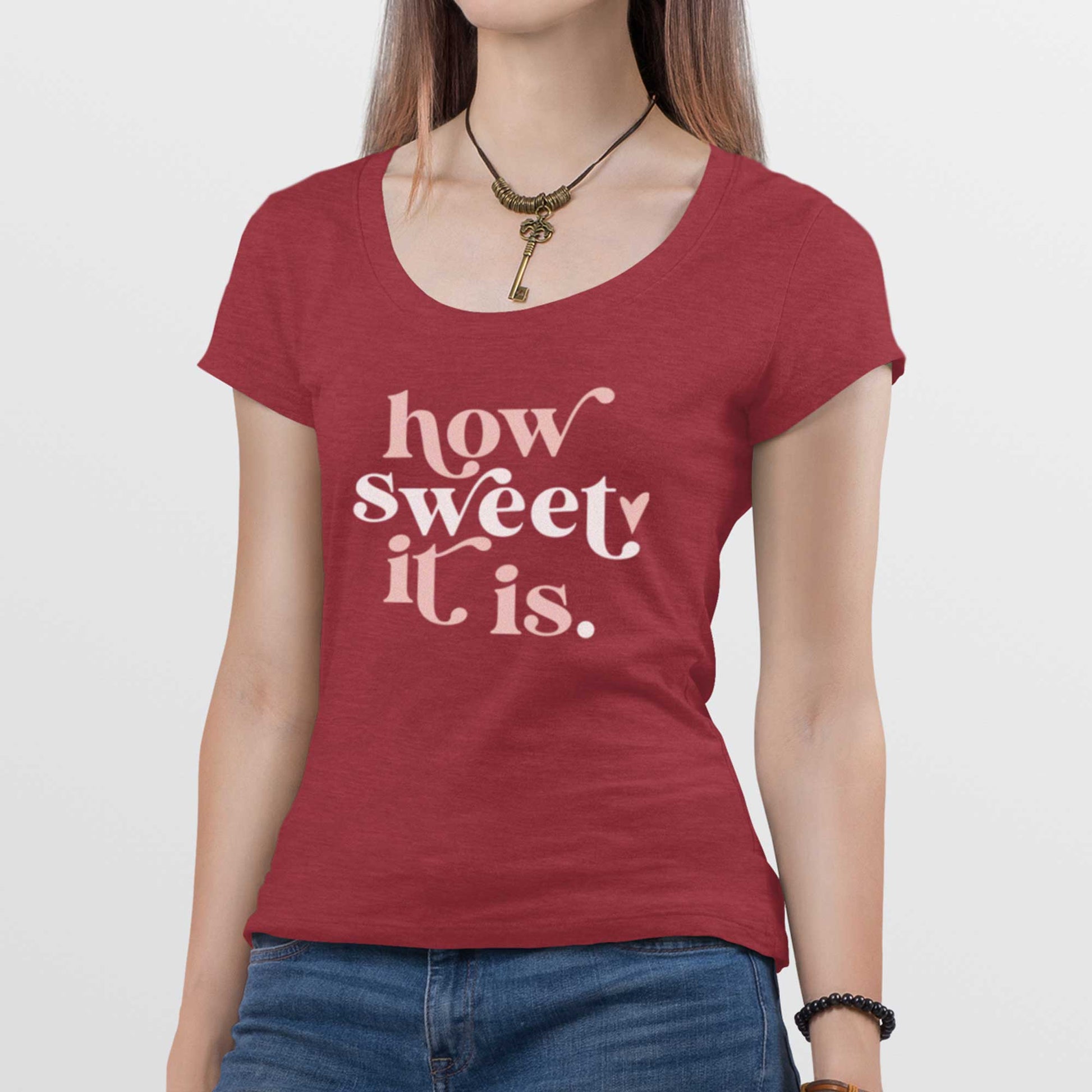 A woman wearing a heathered red District scoop t-shirt featuring the words how sweet it is.