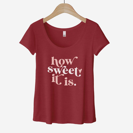A hanging heathered red District scoop neck t-shirt featuring the words how sweet it is.