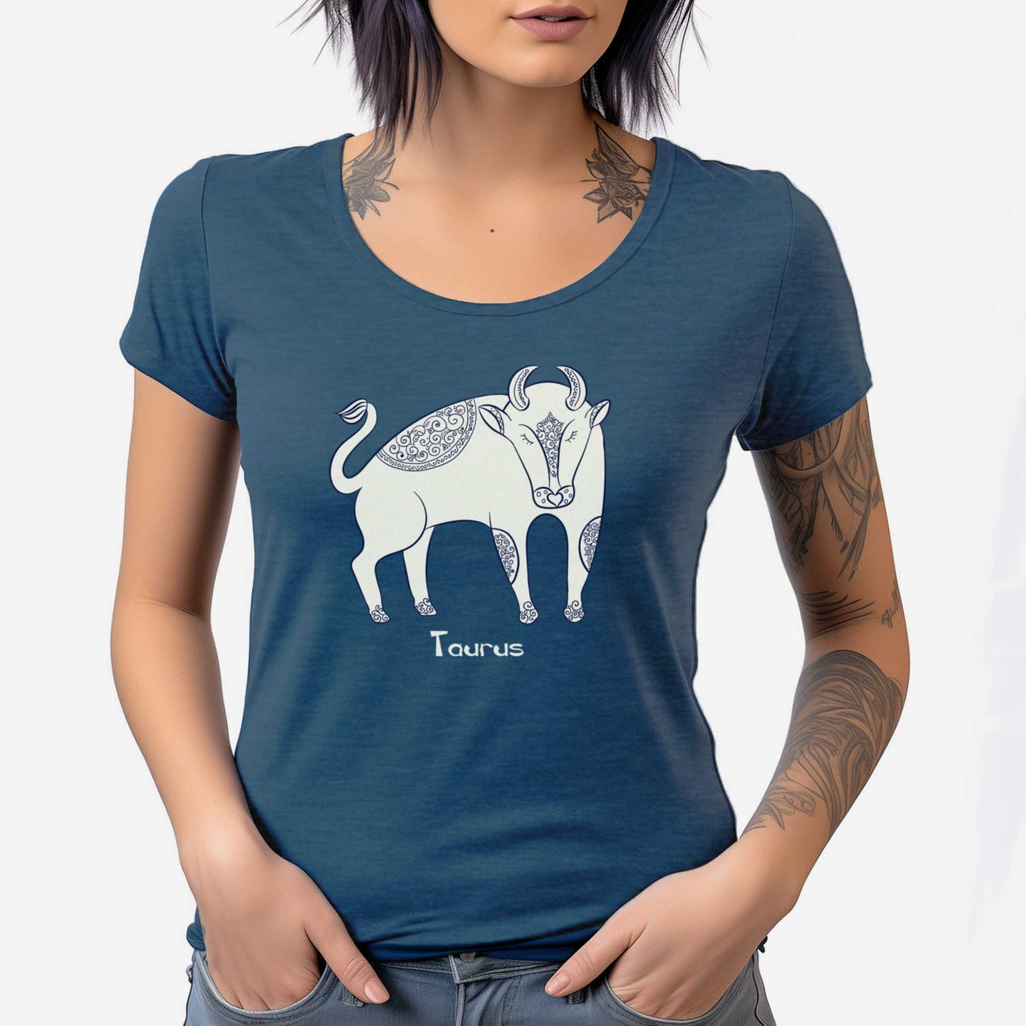 A woman wearing a heathered neptune District 7501 scoop neck t-shirt featuring the zodiac symbol of Taurus, the bull, in a Mediterranean style.