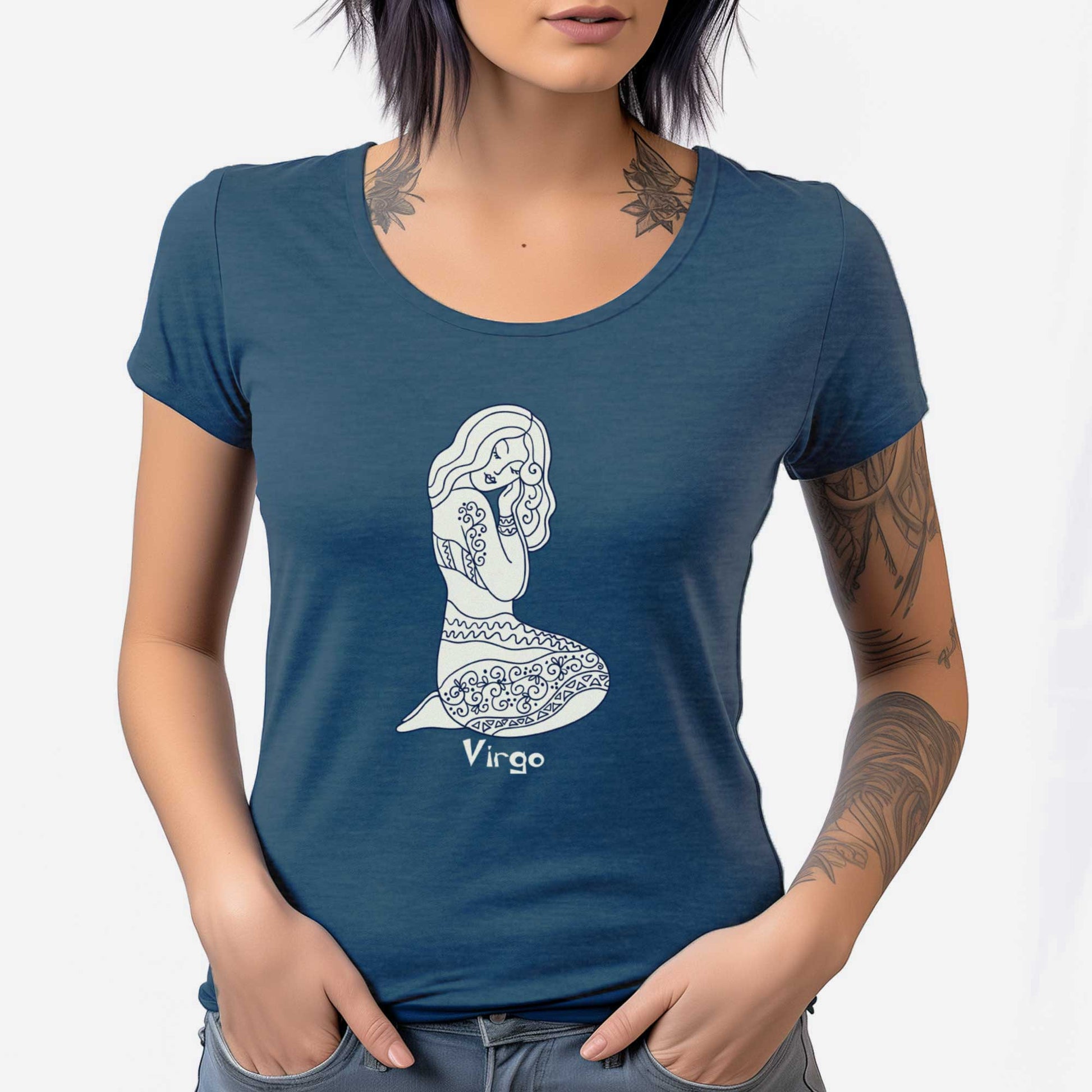 A woman wearing a heathered neptune District 7501 scoop neck t-shirt featuring the zodiac symbol of Virgo, the maiden, in a Mediterranean style.