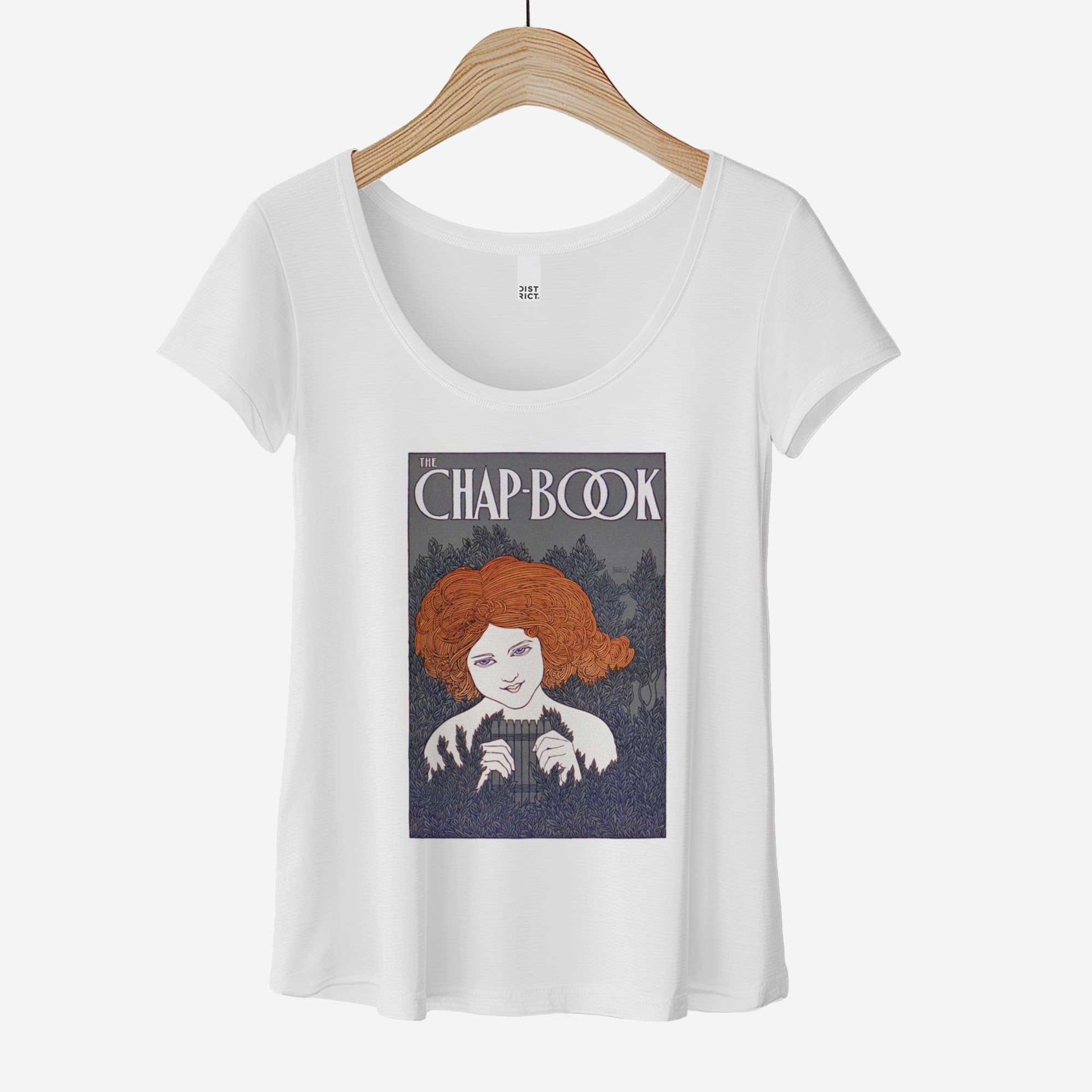 A hanging white District 7501 scoop neck t-shirt featuring a vintage cover of The Chap-Book with an illustration of a young woman in the bushes with a pan flute.