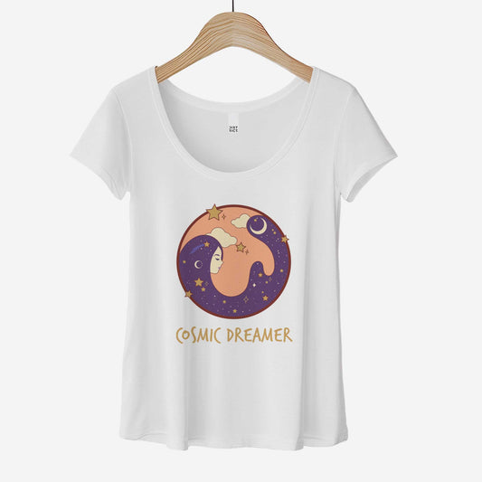 A hanging white District 7501 scoop neck t-shirt featuring a circle with a female face and hair that makes up the night sky and the words cosmic dreamer.