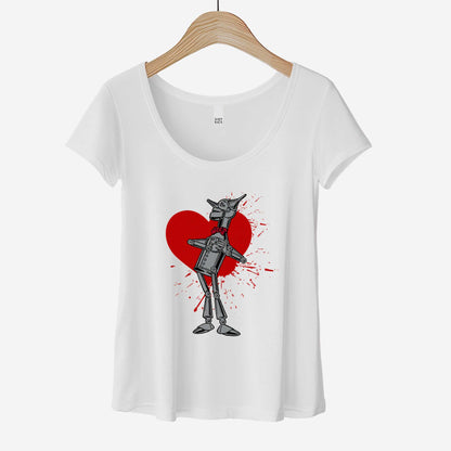 A hanging white District 7501 scoop neck t-shirt featuring a vintage Denslow illustration of the tin man from the Wizard of Oz with a heart symbol spattered behind him.
