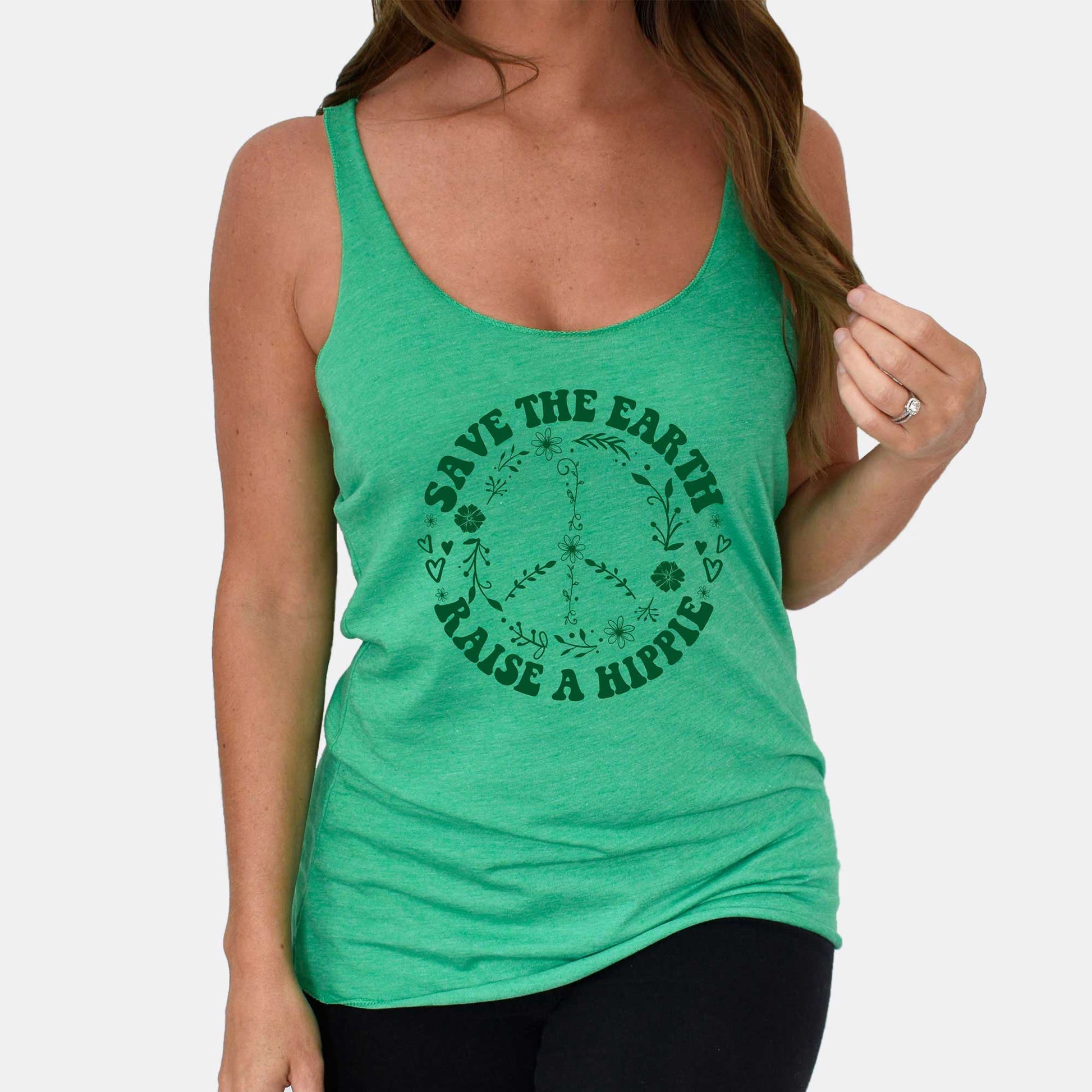 A woman wearing an envy green triblend Next Level racerback tank featuring a peace sign with the words save the earth raise a hippie.