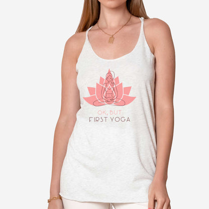 A woman wearing a heather white Next level triblend tank featuring a lotus in the background with a sketch of a woman in the lotus pose and the words ok, but first yoga.