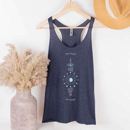 A hanging vintage navy Next Level racerback tank featuring a unalome symbol with the words she found her magic.