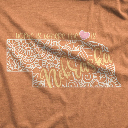 A heather autumn Bella Canvas swatch featuring a mandala in the shape of Nebraska with the words home is where the heart is.