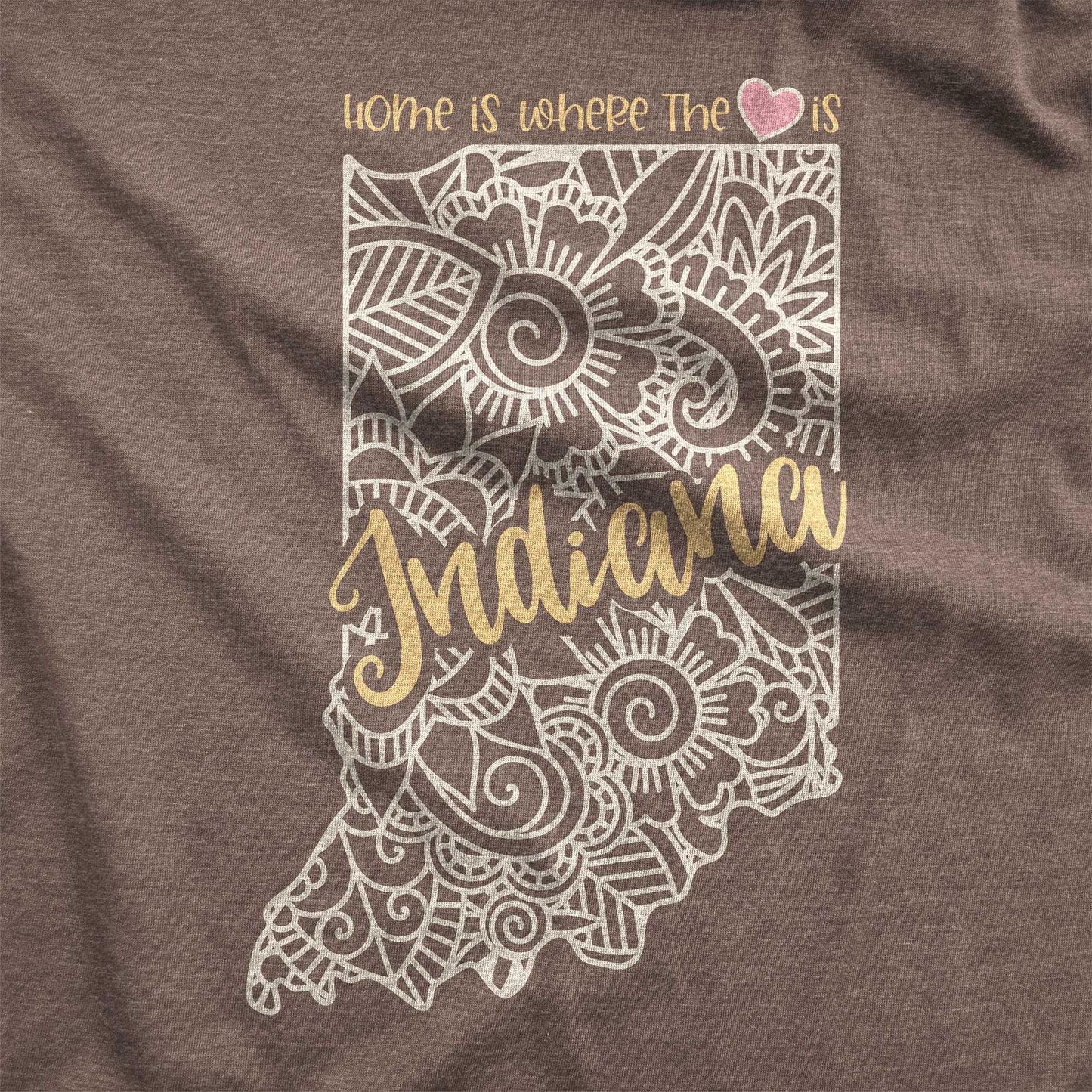 A heather brown Bella Canvas swatch featuring a mandala in the shape of Indiana with the words home is where the heart is.