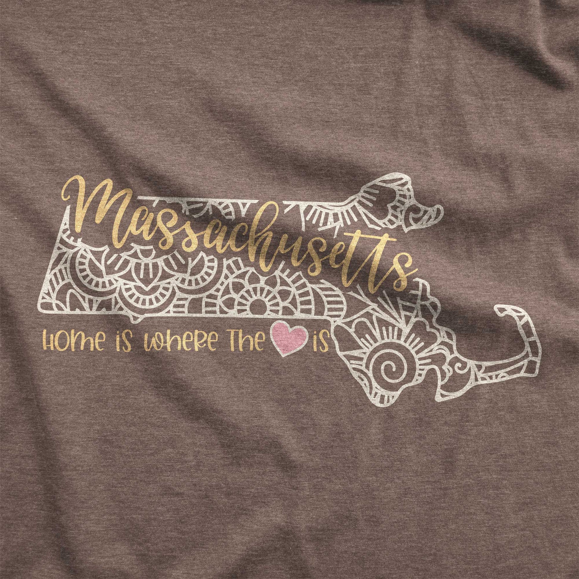 A heather brown Bella Canvas swatch featuring a mandala in the shape of Massachusetts with the words home is where the heart is.