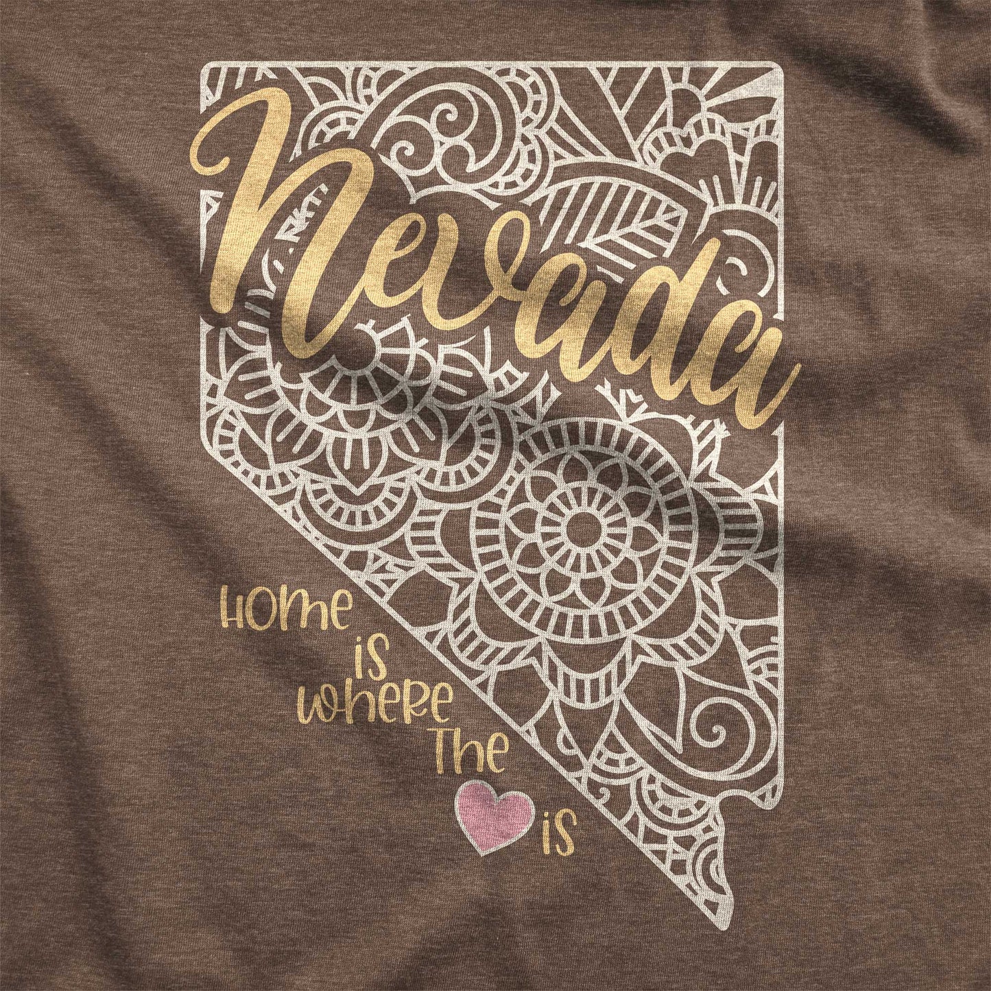 A heather brown Bella Canvas swatch featuring a mandala in the shape of Nevada with the words home is where the heart is.