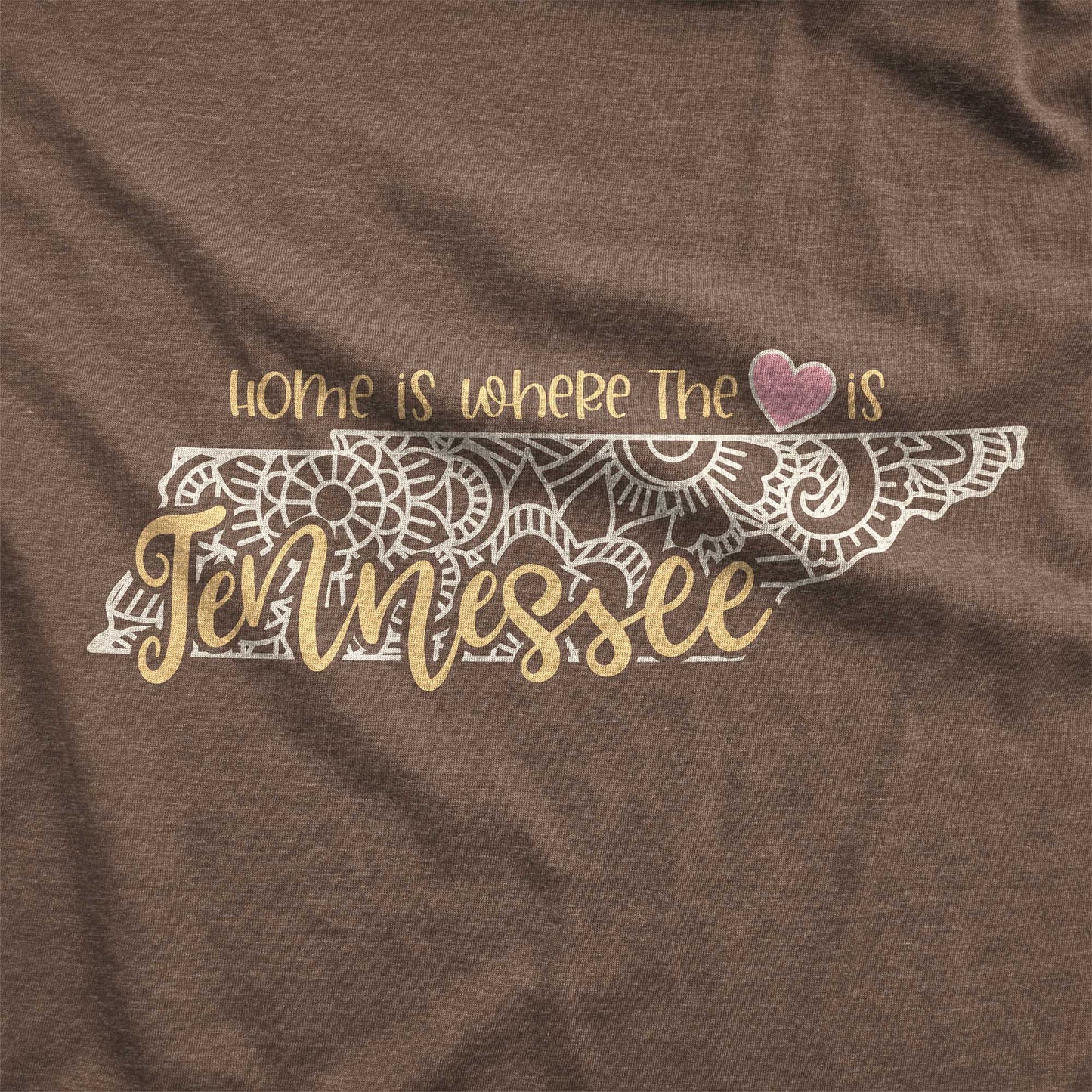 A heather brown Bella Canvas swatch featuring a mandala in the shape of Tennessee with the words home is where the heart is.