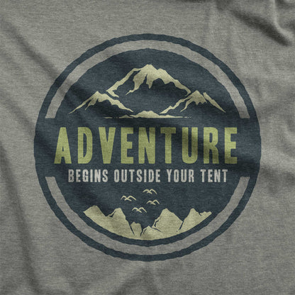 A heather military green Bella Canvas swatch that says adventure begins outside your tent.