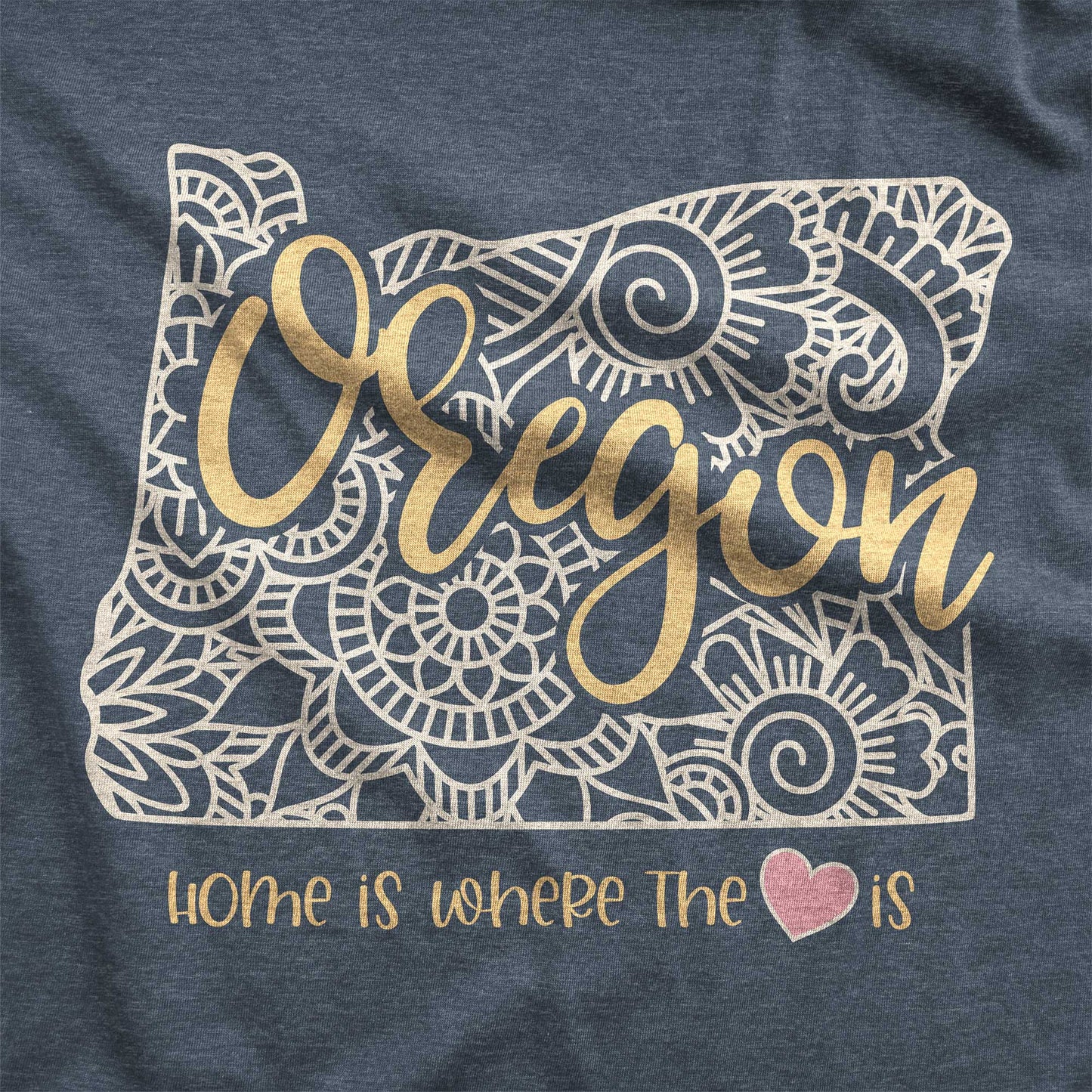 A heather navy Bella Canvas swatch featuring a mandala in the shape of Oregon with the words home is where the heart is.
