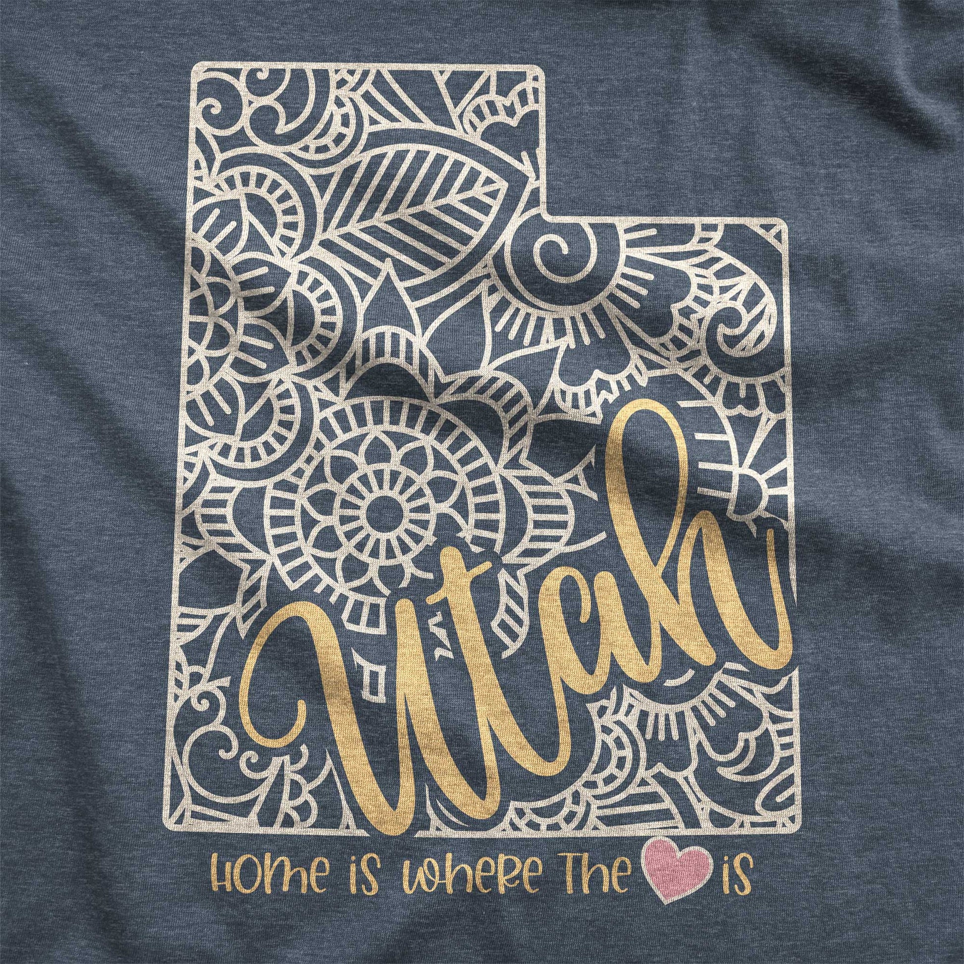A heather navy Bella Canvas swatch featuring a mandala in the shape of Utah with the words home is where the heart is.
