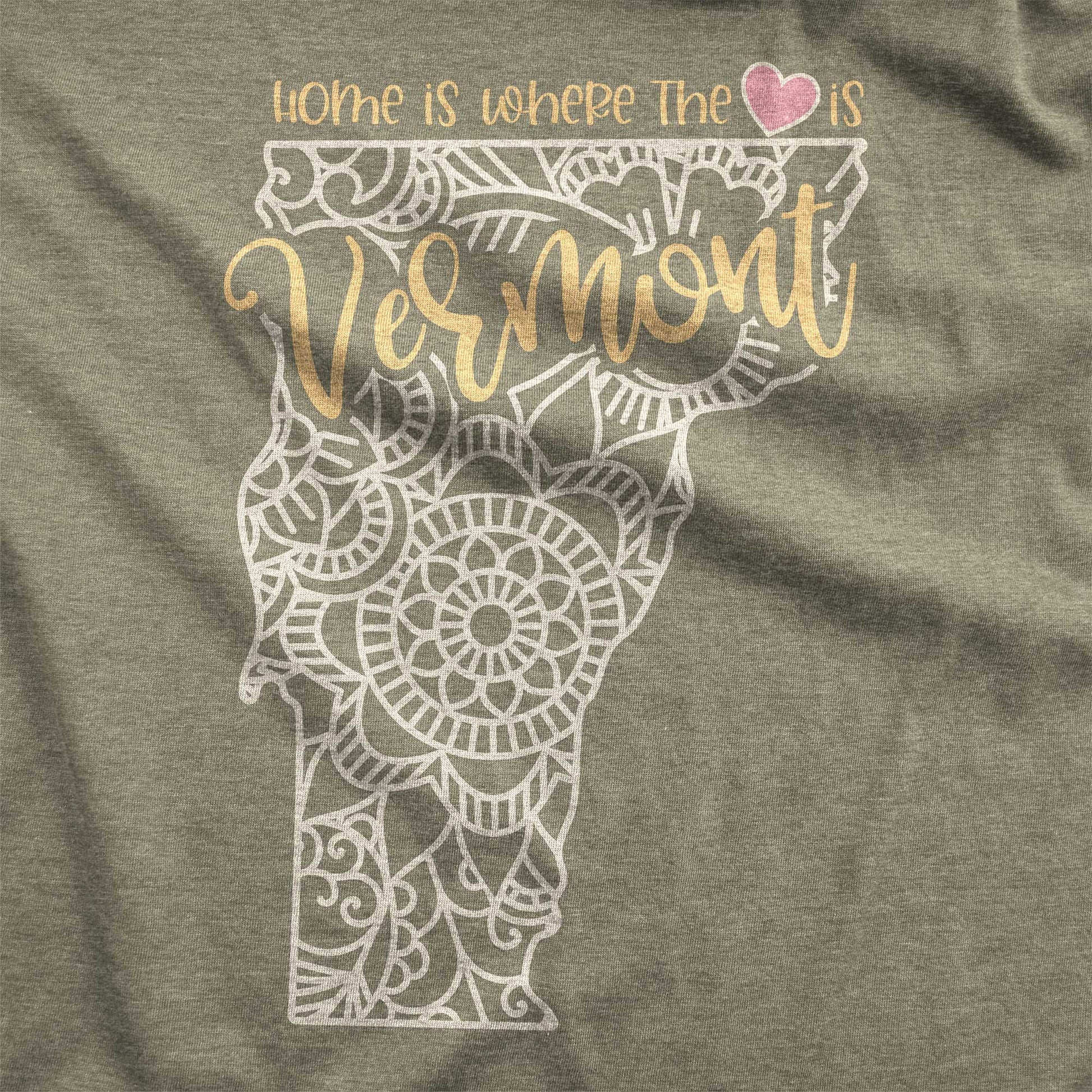 A heather olive Bella Canvas swatch featuring a mandala in the shape of Vermont with the words home is where the heart is.