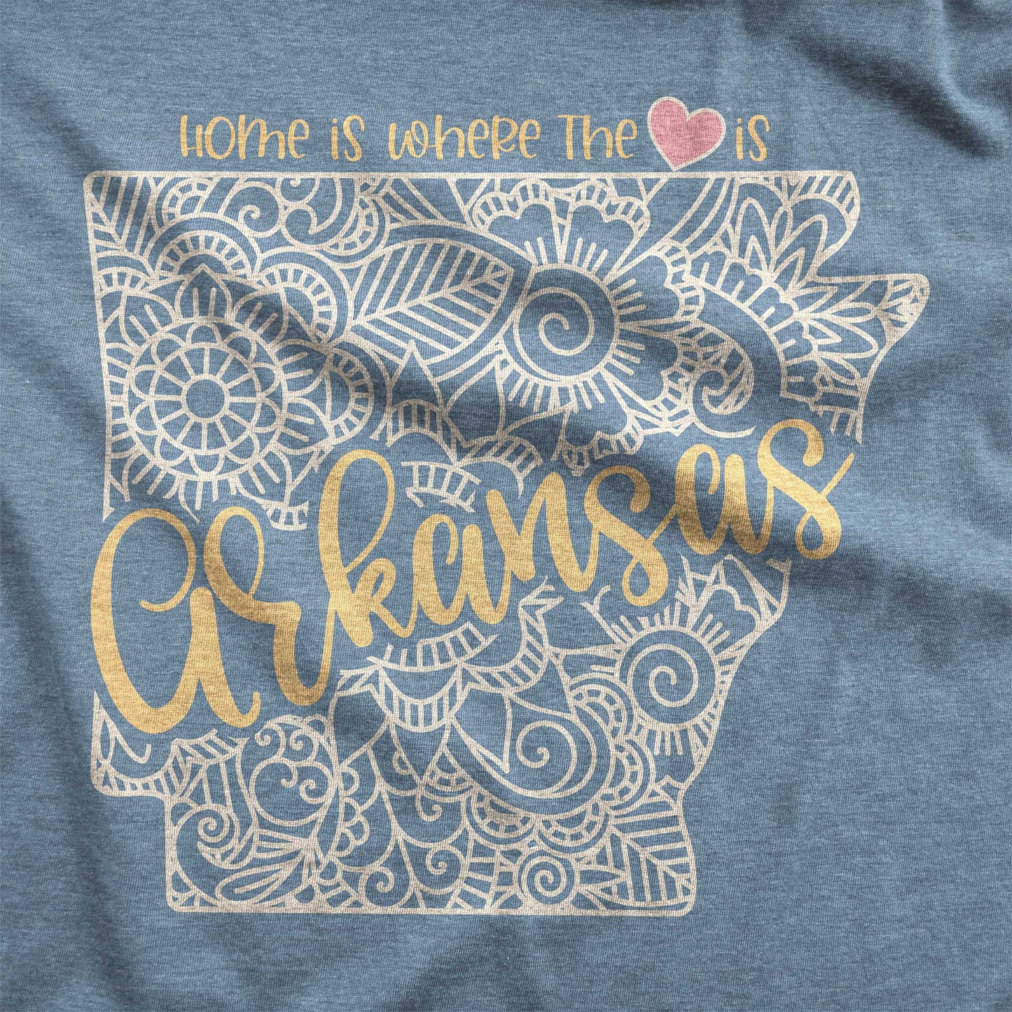 A heather slate Bella Canvas swatch featuring a mandala in the shape of rkansas with the words home is where the heart is.