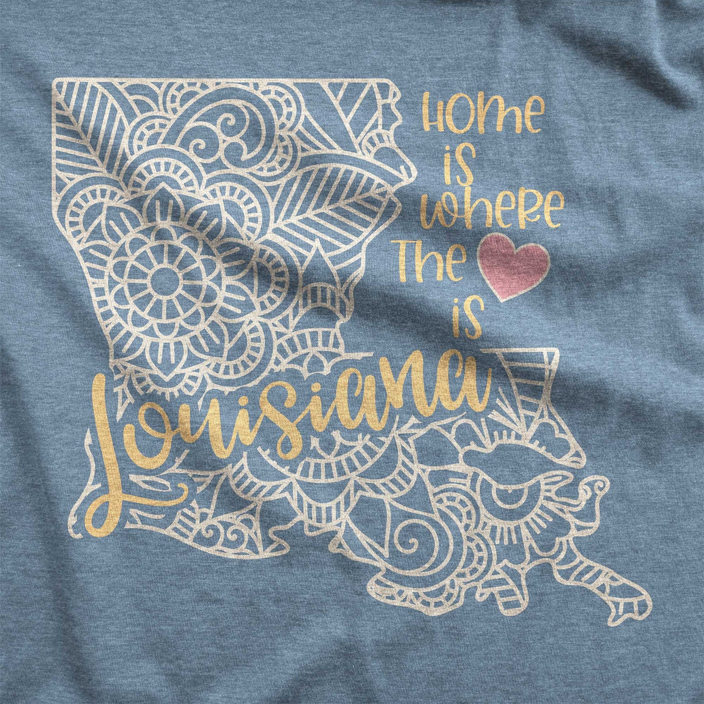 A heather slate Bella Canvas swatch featuring a mandala in the shape of Louisiana with the words home is where the heart is.