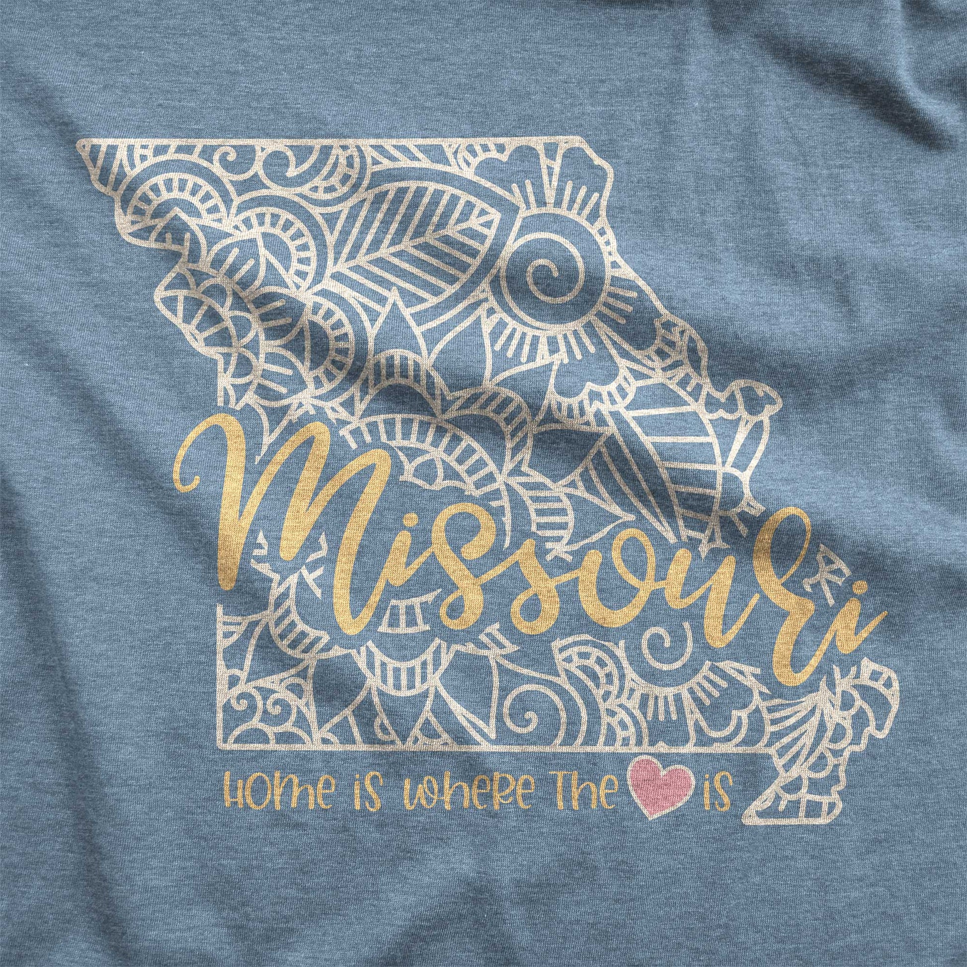 A heather slate Bella Canvas swatch featuring a mandala in the shape of Missouri with the words home is where the heart is.