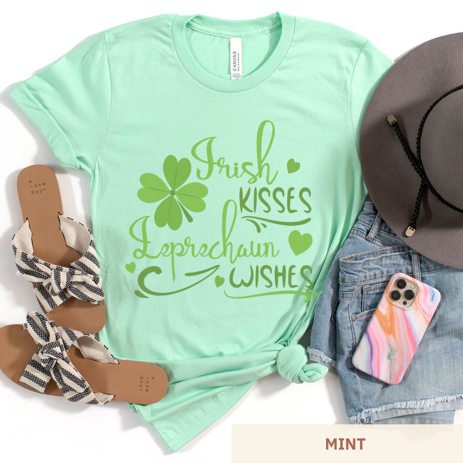 A mint green Bella Canvas t-shirt with a shamrock and the words irish kisses leprachaun wishes